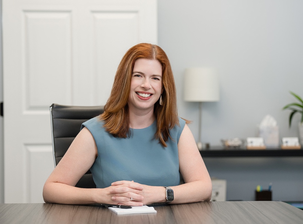 A headshot of Oak City Family Law employee Amy Woods sitting at her desk.