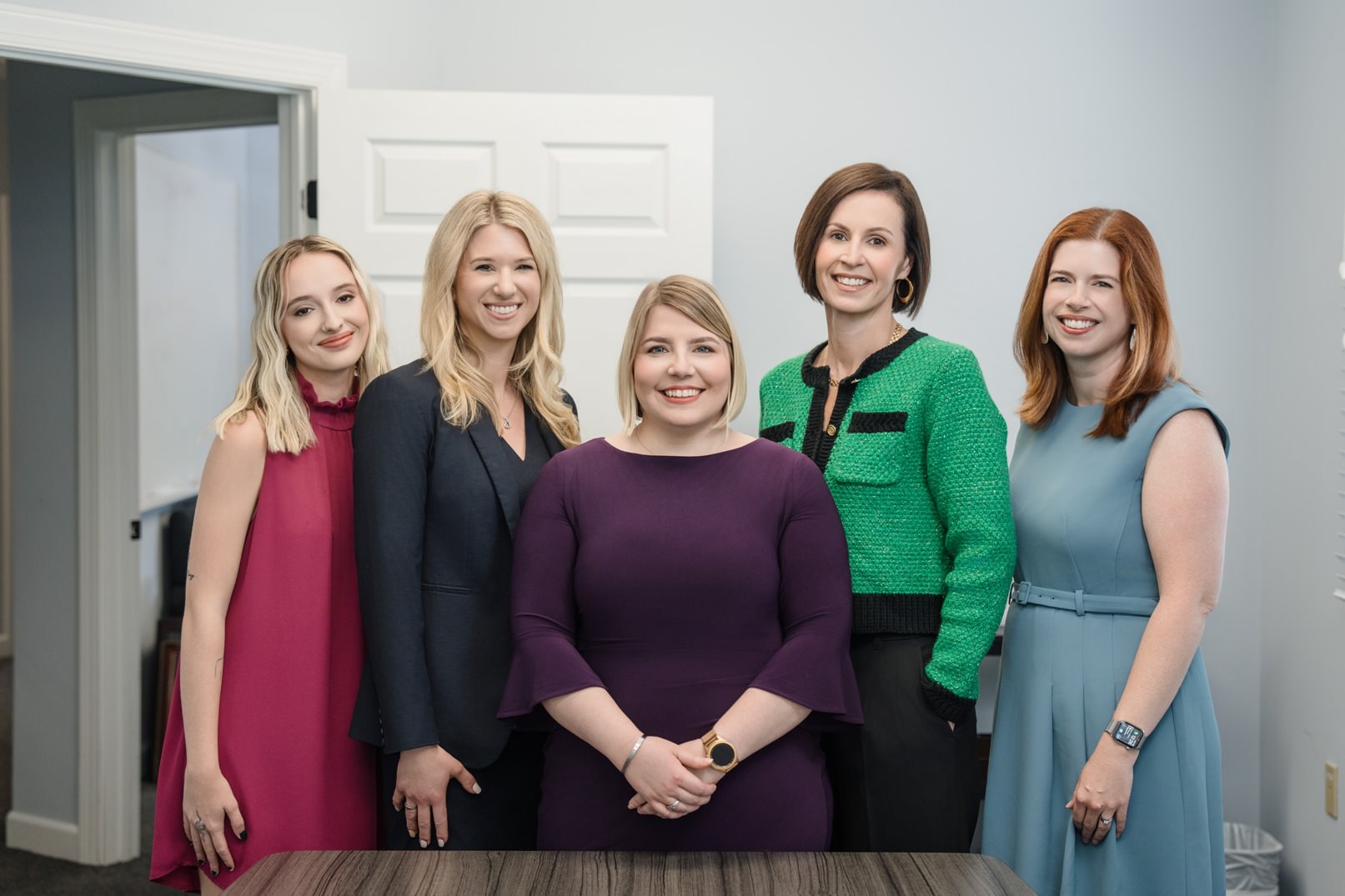 The staff of Raleigh's best family law firm gather around a table for a group photo.