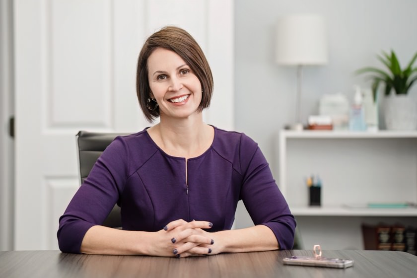 Top Raleigh Divorce Attorney Katherine Frye sits at her desk to assure a client that they will be well cared for.