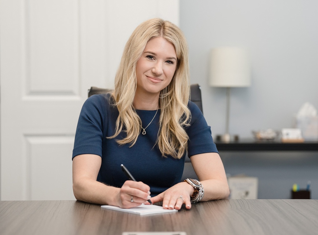 A headshot of Oak City Family Law founding attorney Sarah Privette sitting at her desk.