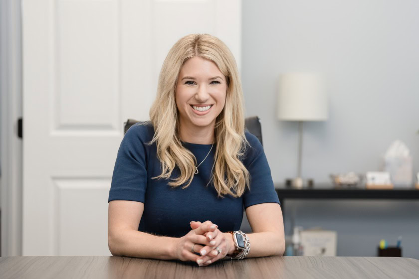 Top Raleigh Domestic Violence Attorney Sarah Privette sits at her desk to listen to a a client in need of a Domestic Violence Protective Order.