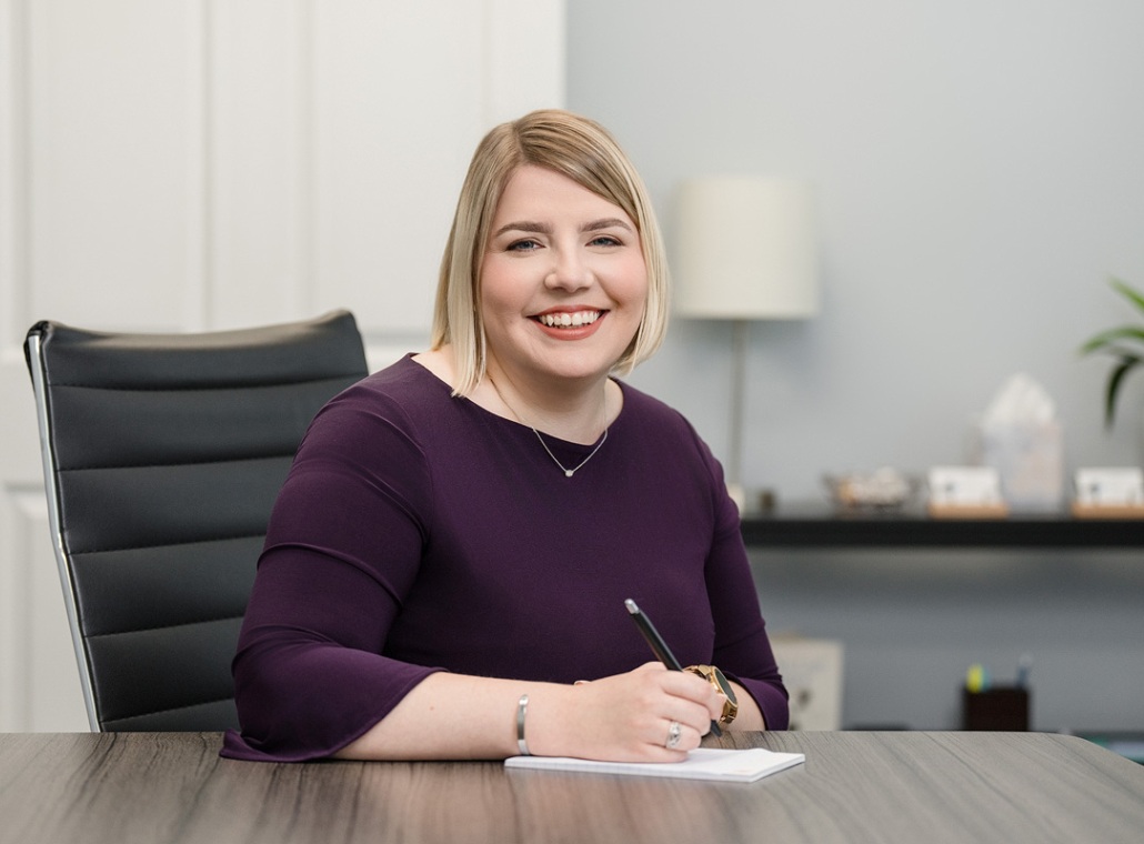 A headshot of Oak City Family Law employee Tylar Rickman sitting at her desk.